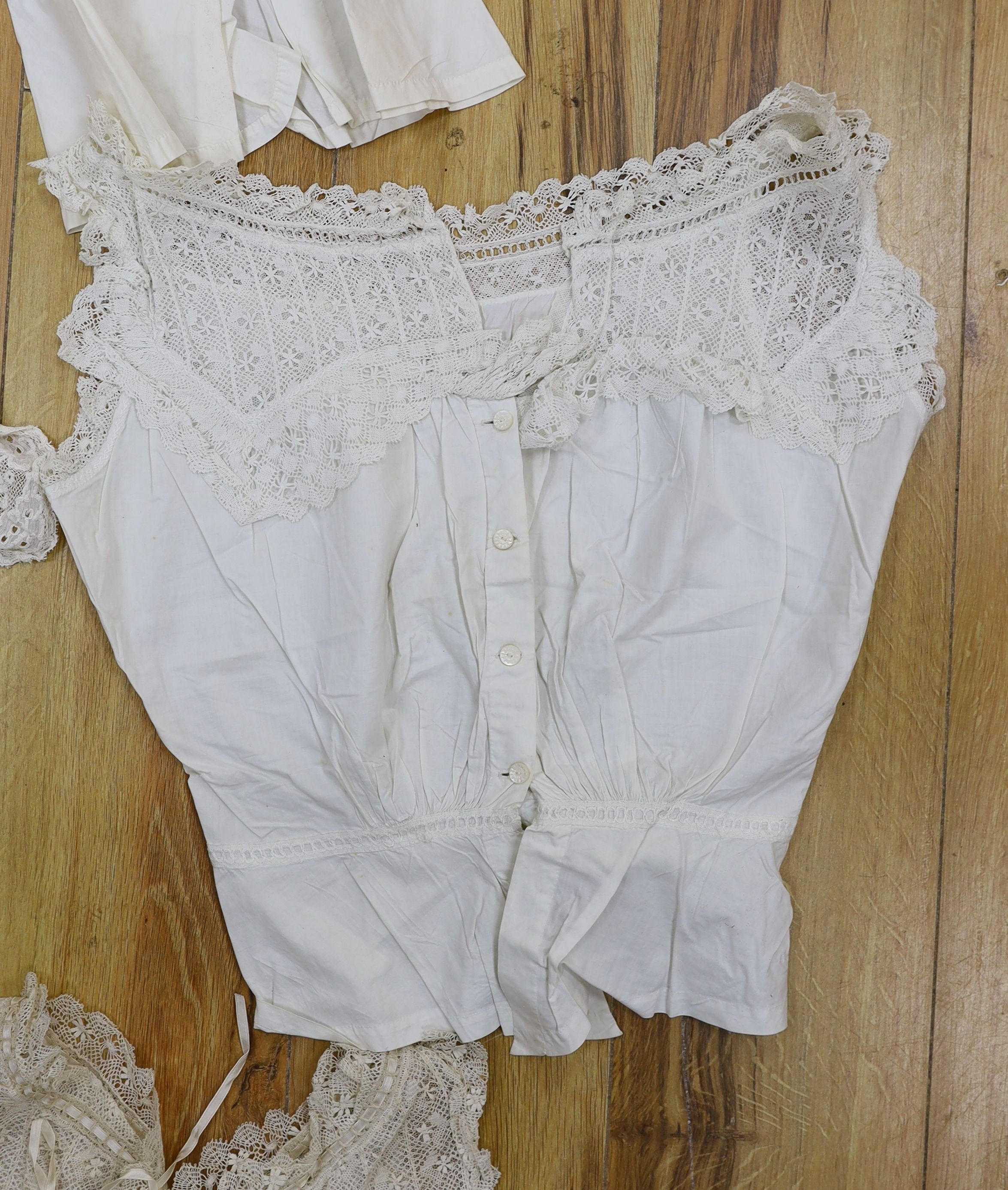Five Victorian and Edwardian lace inserted camisole tops, a cream chemical lace jacket and a whitework and lace petticoat